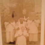 
						This shot of the Migut children, taken in the 1940s in front of the church in the Tengeru camp, faded over time, but upon closer inspection, an image of the Virgin Mary / Blessed Mother can be seen in the background ...					