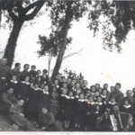 
						Jozef Gazdowicz is holding a child in his arms, on the right side of the photo.					