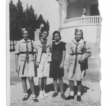 
						Wearing girl guide uniforms (in front of a hospital?)					