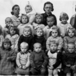 
						Group of children rescued from the Soviet Union in one of the orphanages organized by the Polish Army in Persia. Woman in glasses is my mother Wiktoria Morawska. Infant held by woman to my mother's right is her son, yours truly - Ted Morawski. Since I was born in Isfahan, Iran on Oct. 14, 1942, the picture was most likely taken in 1943.					