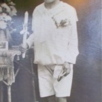 
						Attending Communion, May 1932. Roman told his children that his expression was the result of wearing pants (made from a sister's skirt) that were much too tight due to a lack of communication with his mother. On the previous day, he had injured himself in the groin, jumping fences with friends.					