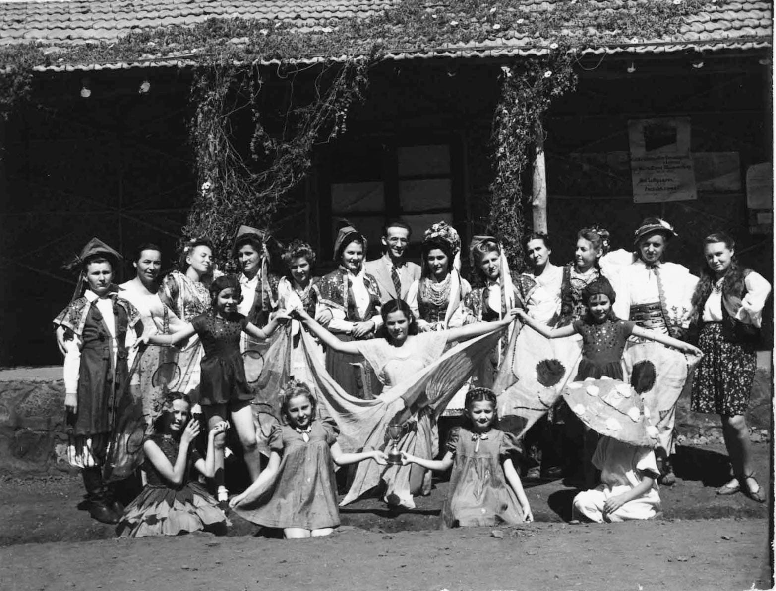 Michał Chmielowiec (standing in the center) from the editorial office of the magazine "Polak w Niechciał" among dancers and children from the dance and vocal group "Bajka", Valivade, 1943; source: Koło Polaków z Niechciał